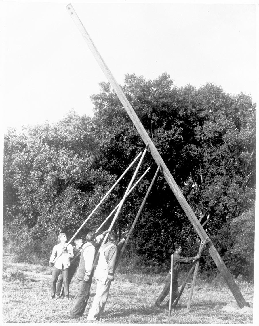 Men hoisting electric pole